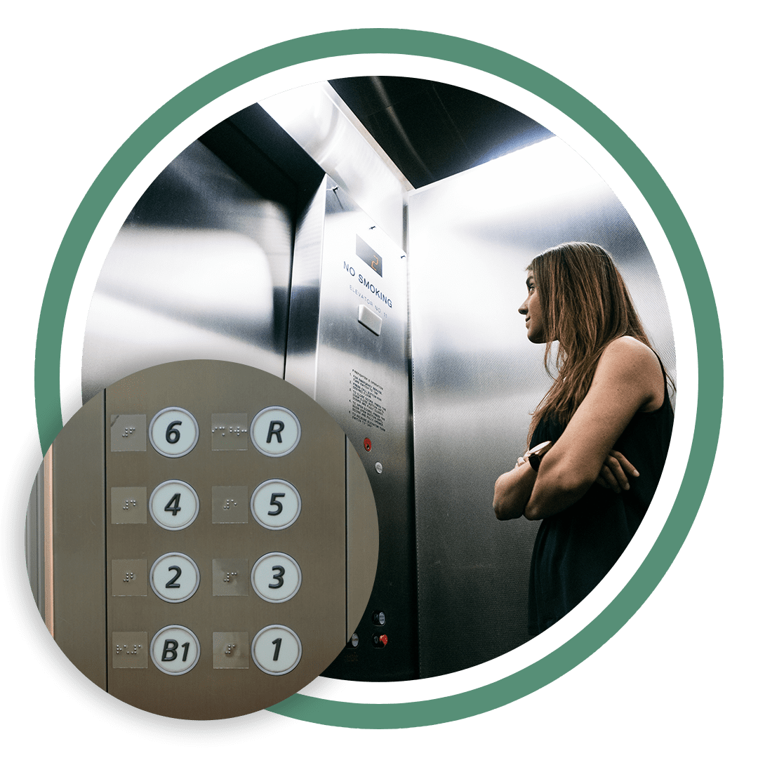 A woman standing in front of an elevator with her arms crossed.